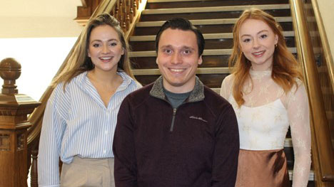 Three people standing on stairs in Wesley Hall