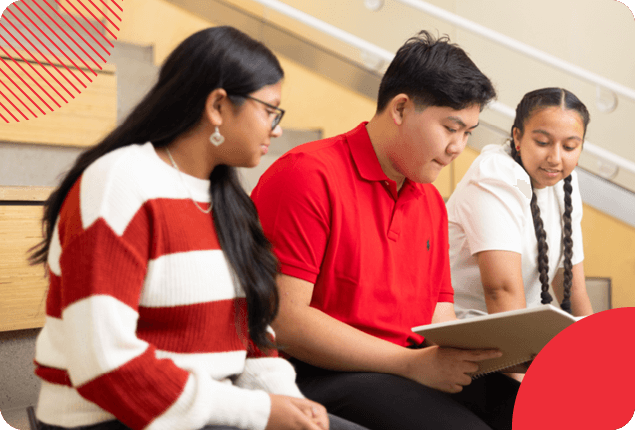 Three students looking a a book