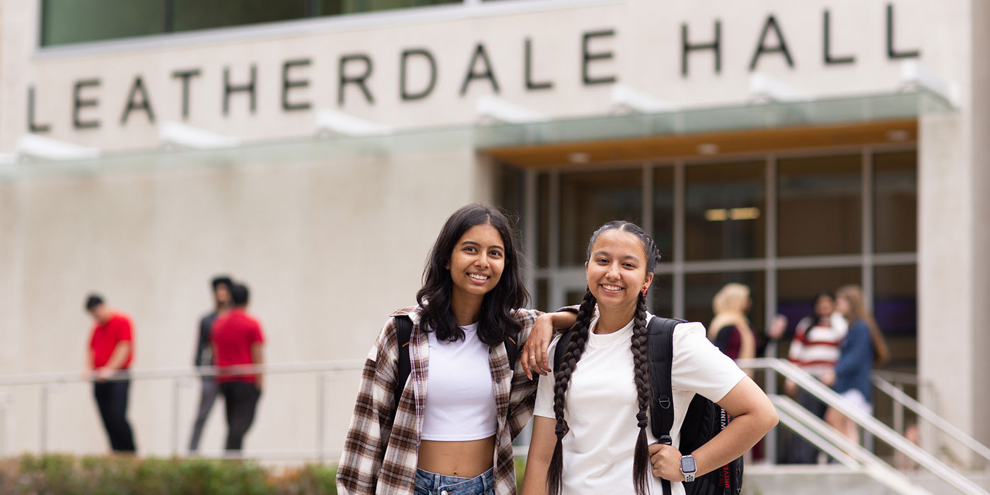 Two students standing in front of Leatherdale Hall smiling at the camera